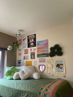 a bed with lots of pillows and pictures on the wall next to it's headboard