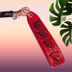 a red keychain with the word love on it next to a monster plant