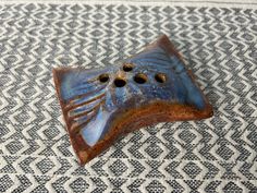 a ceramic object sitting on top of a white and black tablecloth covered floor next to a rug