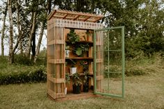 a wooden structure with plants in it on the grass