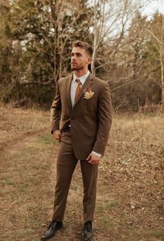 a man in a suit and tie standing in the grass