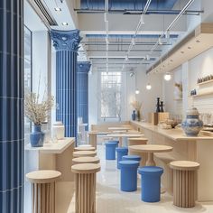 the interior of a store with blue vases and stools in front of it