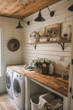 a washer and dryer in a small room with wooden shelves on the wall