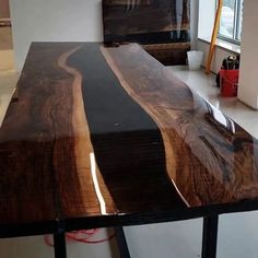 a wooden table sitting in front of a window