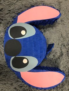 a close up of a paper mache shaped like a blue bird with big eyes