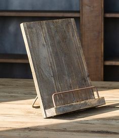 an old wooden tabletop with a metal stand on it's side sitting on a wood table