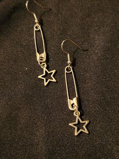 Safety pins on earring hooks, accented with open (hollow) star charms, set of 2 earrings, each measures about 2.5 inches.  Silver tone.  Handmade, unisex jewelry.  Ready to ship. To continue shopping: http://www.rrrobinnn.etsy.com Heart Safety Pin Earrings Target, Cool Earrings Hot Topic, Cheap Silver Hoop Beaded Earrings, Cheap Pendant Necklaces For Streetwear, Affordable Handmade Star Earrings, Cheap Trendy Dangle Charms, Cheap Adjustable Jewelry For School, Luxury Modern Metal Plug Earrings, Luxury Hammered Fine Jewelry Necklaces