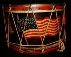 an old drum with the american flag painted on it's side and ropes hanging down