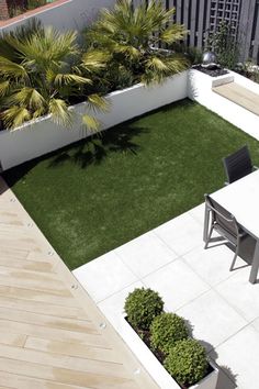 an aerial view of a small backyard with grass and potted plants in the center