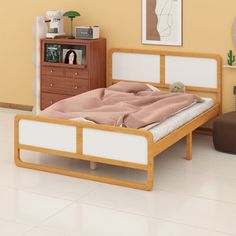 a bed sitting next to a dresser in a bedroom