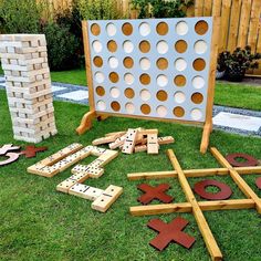 an outdoor game set up in the grass with wooden pegs and giant connect boards