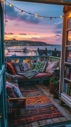 an open door to a balcony with lots of pillows and rugs