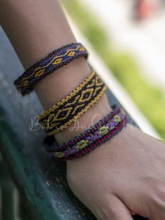 a woman's hand with two bracelets on her wrist