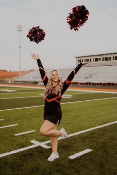 a cheerleader on the football field with her pom poms in the air