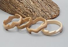 three wooden rings sitting next to a piece of wood