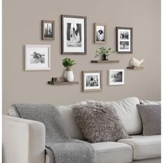 a living room filled with furniture and pictures on the wall next to a white couch