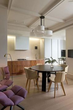 a dining room table surrounded by chairs and lights