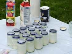 a table topped with lots of different types of condiments next to bottles of milk