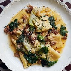 a white plate topped with pasta and spinach