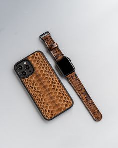 an iphone case with a snake skin pattern on the back and a watch strap attached to it