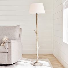 a living room with a chair, lamp and teddy bear on the rug in front of it