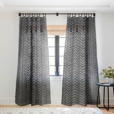 a living room with white walls and grey curtains