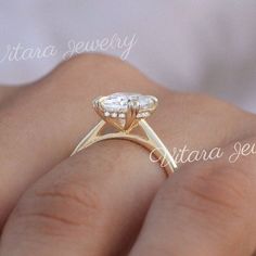 a close up of a person's hand with a gold ring on it and a diamond in the middle