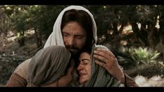 jesus and mary embracing each other with trees in the background