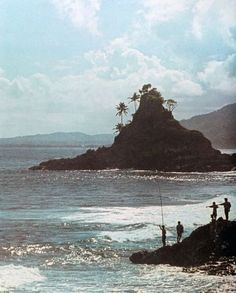 two men fishing off the shore of an island