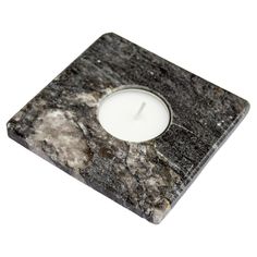 a marble candle holder with a lit candle