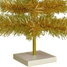 a small gold christmas tree on a white base with no decorations or ornaments in it