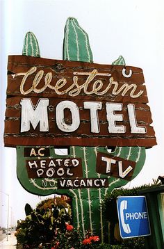 the western motel sign is painted green and brown