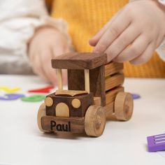 a child playing with a wooden toy truck