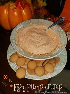 a plate with cookies and peanut butter on it next to a bowl full of pumpkin dip