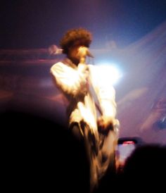 a man standing on top of a stage holding a microphone