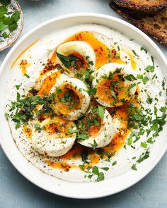 an egg dish is served on a plate with bread and parsley sprinkled around it