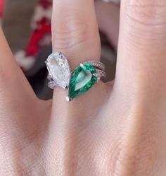 a woman's engagement ring with an emerald and diamond