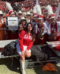 a group of women in red and white marching outfits posing for a photo on a bench