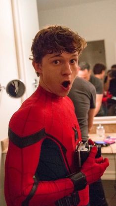 a man in a spiderman costume with his mouth open