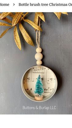 an ornament with a christmas tree on it and music notes hanging from the top