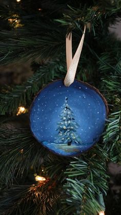 a blue ornament hanging from a christmas tree