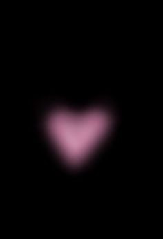 a heart shaped object in the dark with pink light coming from it's center