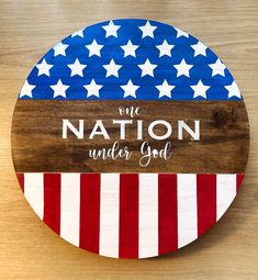 a wooden sign with the words one nation under god painted on it and an american flag