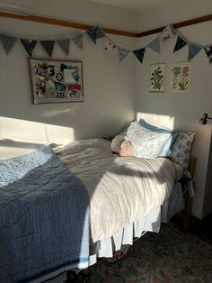 a small bed in a room with blue and white decorations on the wall above it