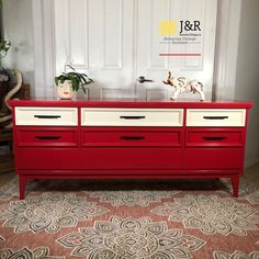 a red and white dresser sitting in front of a door