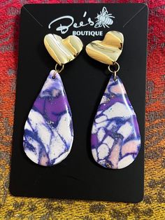 Amazing purple earrings handcrafted with clay and resin mixing the colors with gold flakes and a pearl. Stud/ The earring itself is approximately 2.5 inches. The shipping envelope is 8 x 4 x 0.25. The price is per pair. Custom orders are available. Hand Painted Purple Earrings As Gift, Gold Teardrop Earrings Hand Painted, Gold Hand-painted Teardrop Earrings, Gold Hand Painted Teardrop Earrings, Purple Resin Drop Earrings, Unique Purple Polymer Clay Earrings, Trendy Handmade Purple Earrings, Purple Resin Earrings As Gift, Purple Resin Earrings As A Gift