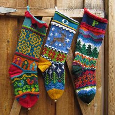 three colorful knitted socks hanging on a wooden fence with text overlay that reads, free knitting pattern