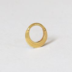 a gold ring sitting on top of a white surface