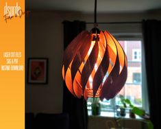 an orange paper lantern hanging from a ceiling