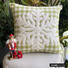 a nutcracker figurine sitting next to a decorative pillow